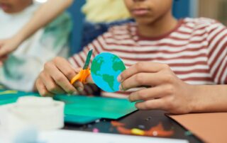 boy with cut out paper earth