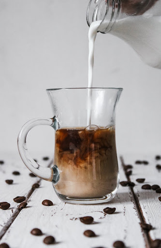milk pouring into a cup of coffee