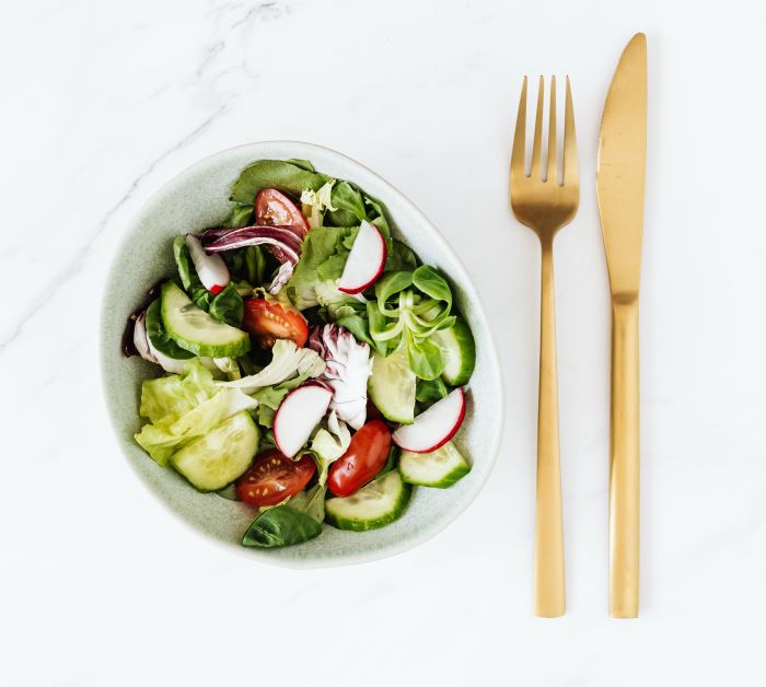 salad on plate with fork and knife