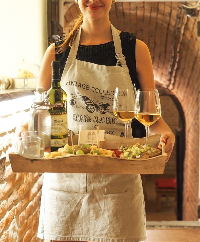 woman server carrying tray of food and drinks